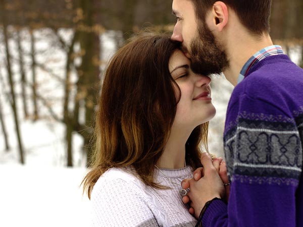 A man kissing a Ukrainian woman on her forehead.