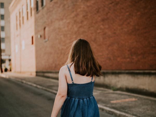 back view of woman in blue walking away